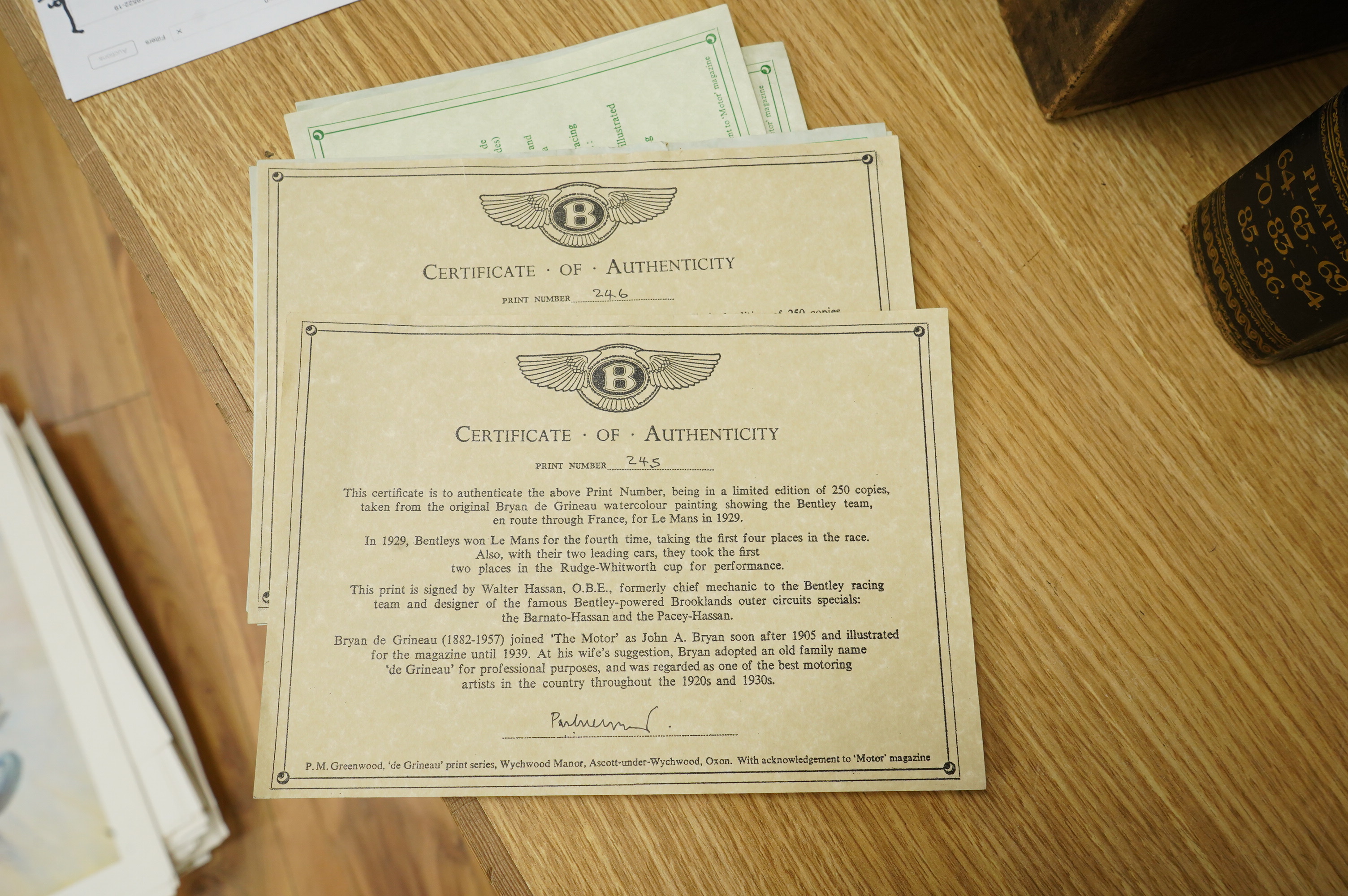 Two framed and signed motor racing lithographs by Anthony Heal and Walter Hassan of Le Mans and Brookslands racing scenes, the largest frame 61.5 x 76cm, together with a folio containing a large number of unframed simila